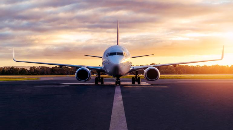 Sunset view of airplane on airport runway under dramatic sky in Hobart,Tasmania, Australia. Aviation technology and world travel concept.