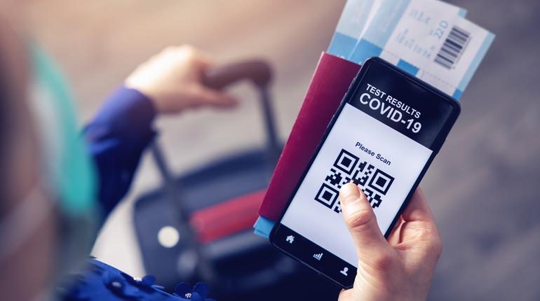 person in airport using mobile app in phone to show covid-19 test results for travel